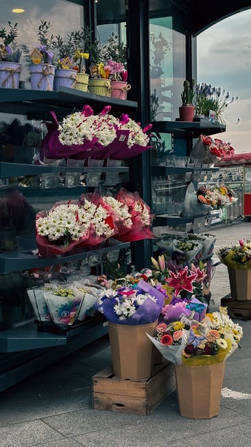 A display of fresh floral arrangements and bouquets at a flower shop on Hoddesdon High Street, featuring a variety of flower types and vibrant colours. The arrangement includes pink, white, and purple